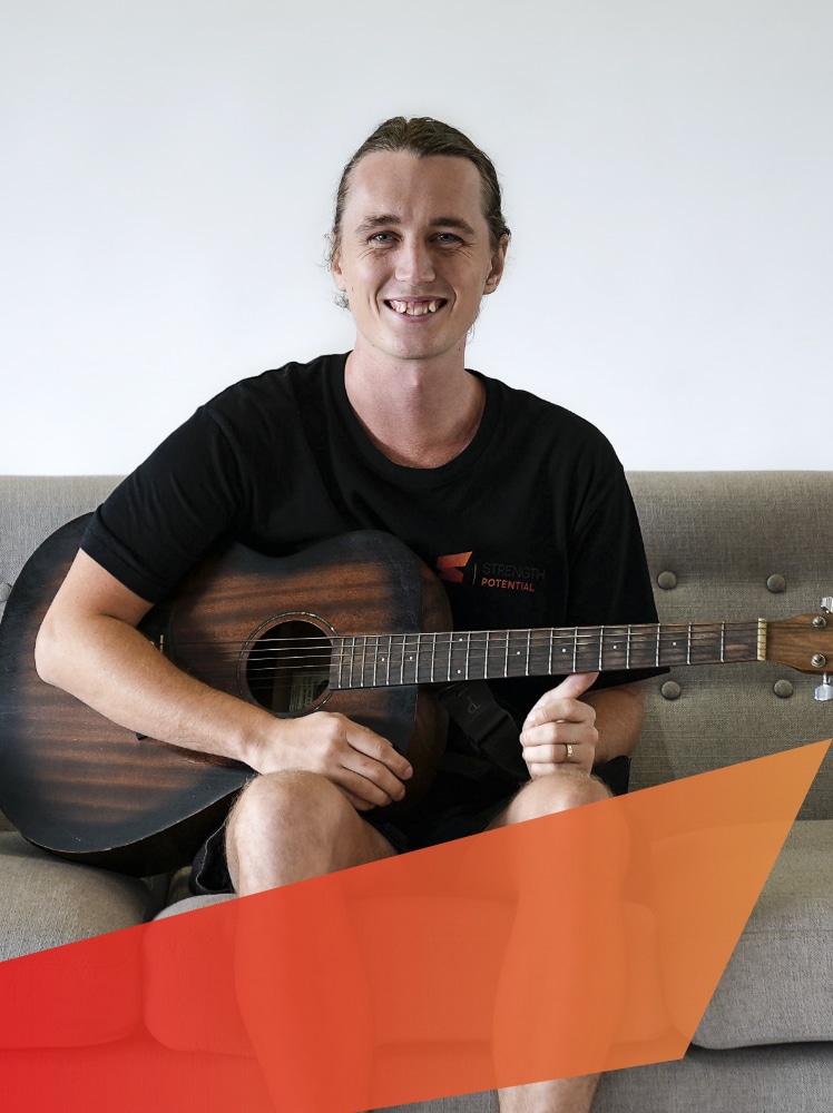 strength-potential-mentor-and-support-worker-Jesse-Stoddart-portrait-with-acoustic-guitar-expressing-his-personal-interests-and-hobbies-1