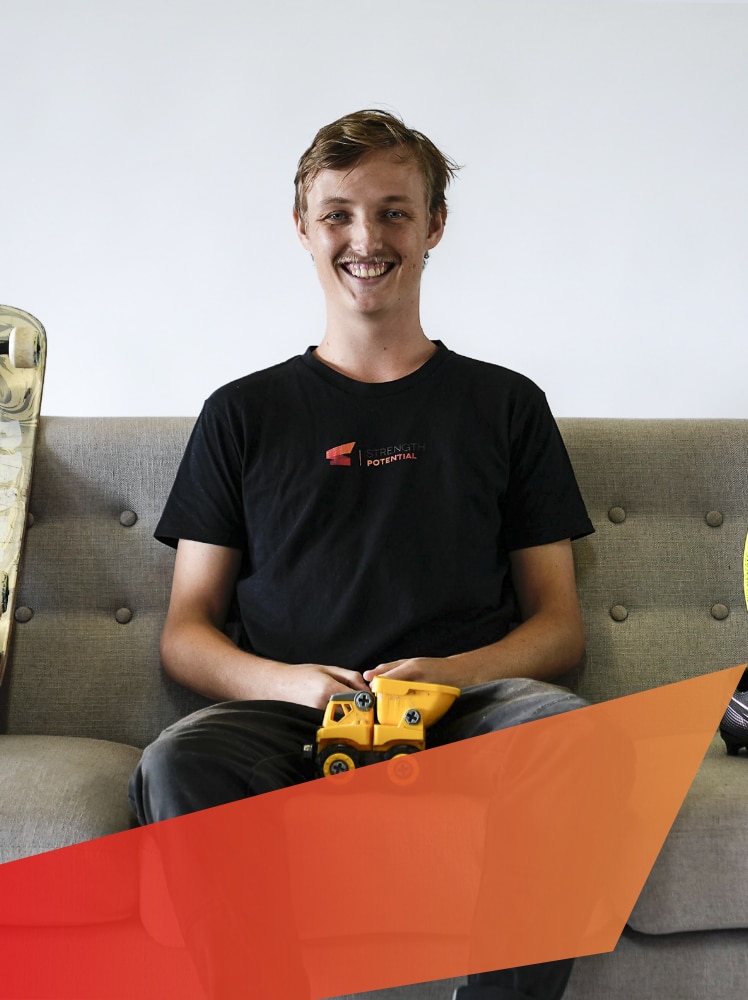 strength-potential-mentor-and-support-worker-Luke-Birch-portrait-with-skateboard-and-toy-truck-expressing-his-personal-interests-and-hobbies